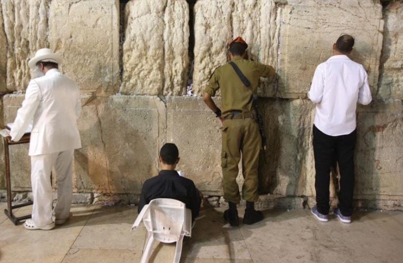 JEWS MOURN the destruction of the First and Second Temples at the Western Wall last night (photo credit: MARC ISRAEL SELLEM/THE JERUSALEM POST)