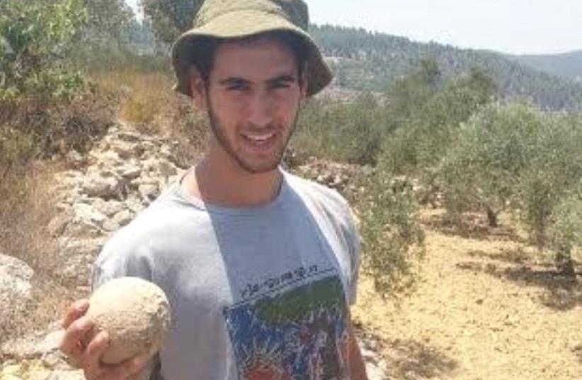 A student from the Kfar Etzion Field School holds a stone ballista ball used during the legendary Bar Kokhba revolt.  (photo credit: COURTESY AMICHAI NOAM)