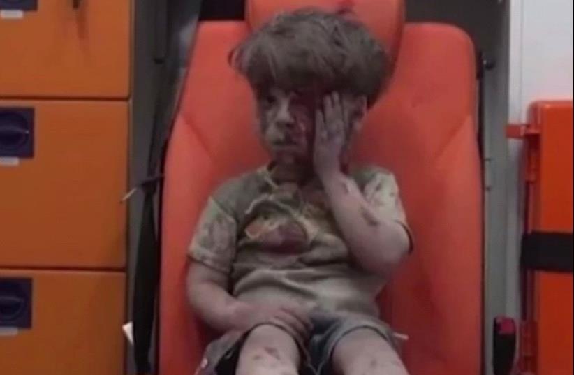 Young Omran Daqneesh, bloodied and dazed, was pulled from the rubble in Aleppo. (photo credit: screenshot)