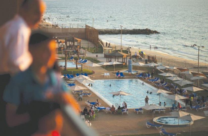 Palestinians are seen at the Blue Beach Resort in Gaza shortly after it opened in July 2015 (photo credit: MOHAMMED SALEM/REUTERS)