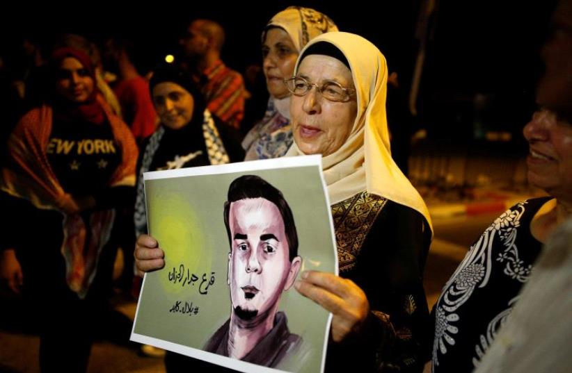 The mother of the hunger-striking Palestinian prisoner Bilal Kayed holds his picture during a protest in favour of his release, at Barzilai Hospital in the southern Israeli city of Ashkelon August 9, 2016 (photo credit: REUTERS)