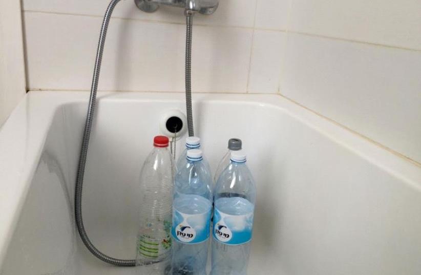 Rehovot residents filled up old bottles with water in preparation for water shut off.  (photo credit: SHARON UDASIN)