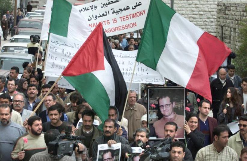 Palestinian and Italian flags during a march in Italy. (photo credit: JAMAL ARURI / AFP)