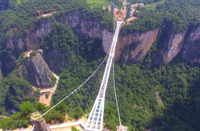 People visit a glass bridge at a gorge as it opens to the public in Zhangjiajie, Hunan Province, China (photo credit: REUTERS)