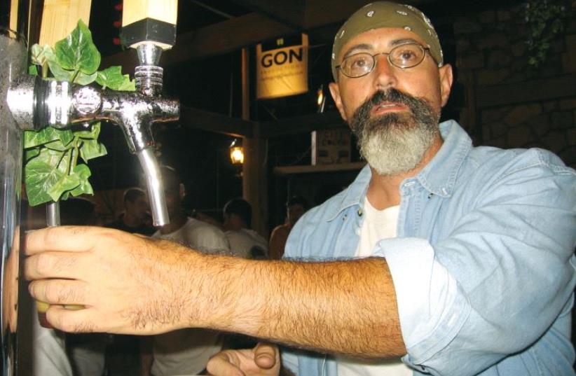 David Cohen, founder of Dancing Camel Brewery, pumps beer in his trademark bandana (photo credit: DANCING CAMEL BREWERY)