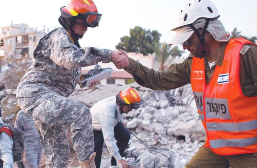 IDF SOLDIERS and US Army observers stand on rubble during an earthquake drill in Holon in October 2012. (photo credit: NIR ELIAS / REUTERS)