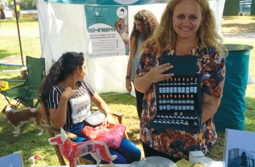 ANAT AMIR-AMANO, an expert in medicines and therapies for pets, displays some of her remedies for anxious dogs and cats during Tel Aviv’s ‘Dog Day’ on Friday. (photo credit: SHARON UDASIN)