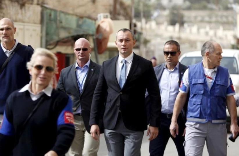 Nickolay Mladenov (C), the United Nations Secretary-General Special Representative to the Middle East, looks at Israeli soldiers during his visit to the West Bank city of Hebron November 4, 2015. (photo credit: REUTERS)