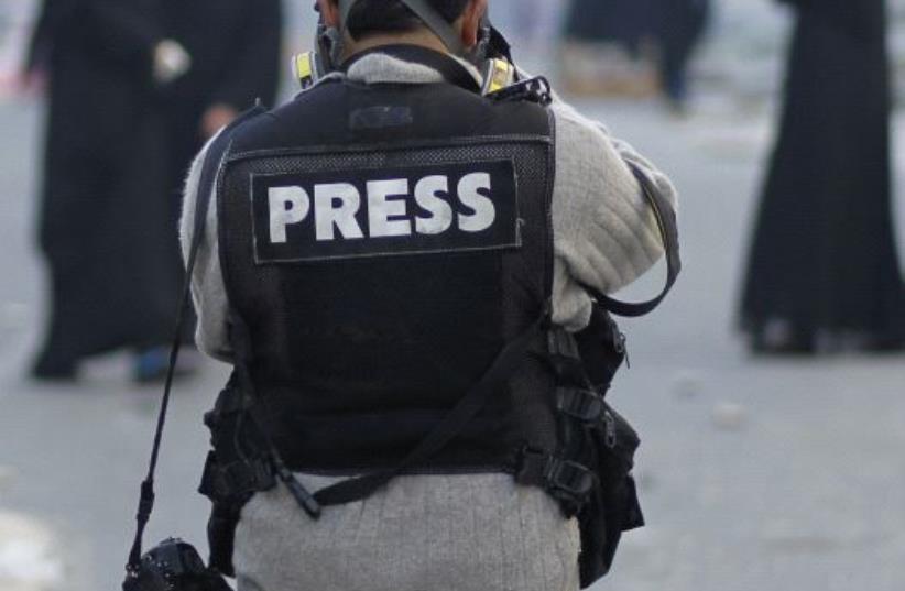 A photojournalist in a press vest [Illustrative] (photo credit: REUTERS)
