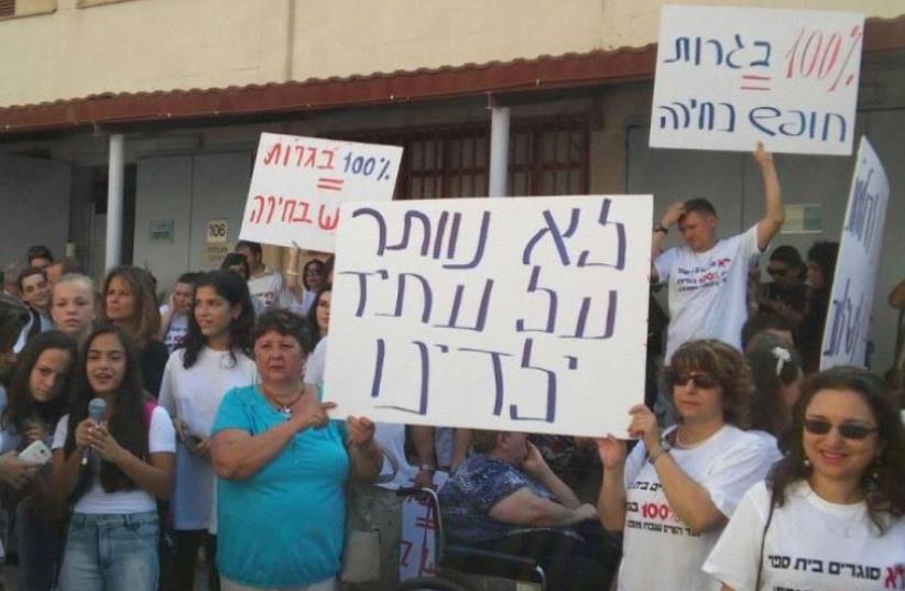 Protestor's outside of the Shevah Mofet School hold signs reading: "We won't give up on our children's future."  (photo credit: OFER LAVNT/ MAARIV)