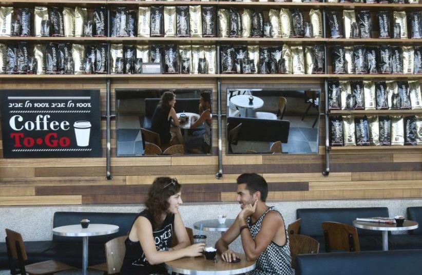 A couple relax at a branch of Aroma in Tel Aviv, one of Israel’s most successful coffee chains (photo credit: MARC ISRAEL SELLEM)