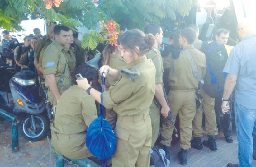 FRUSTRATED SOLDIERS wait outside the Arlozorov Bus Terminal in northeastern Tel Aviv. (photo credit: ELIYAHU KAMISHER)