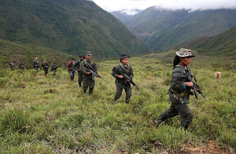 WILL ALL this be over now? Members of the 51st Front of the Revolutionary Armed Forces of Colombia (FARC) patrol in the remote mountains of Colombia, last month (photo credit: REUTERS)