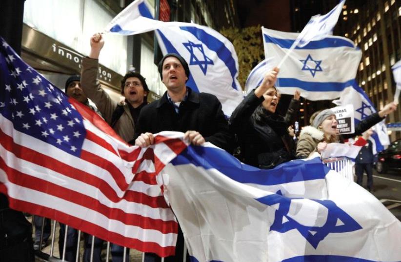 People wave American and Israeli flags‏ (photo credit: REUTERS)