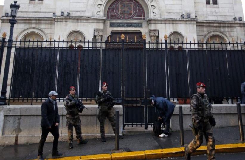Armed French soldiers stand in front of a Synagogue during a visit of French Interior Minister Bernard Cazeneuve after an attack in front of a Jewish school in Marseille's 9th district, France, January 14, 2016. (photo credit: REUTERS/JEAN-PAUL PELISSIER)