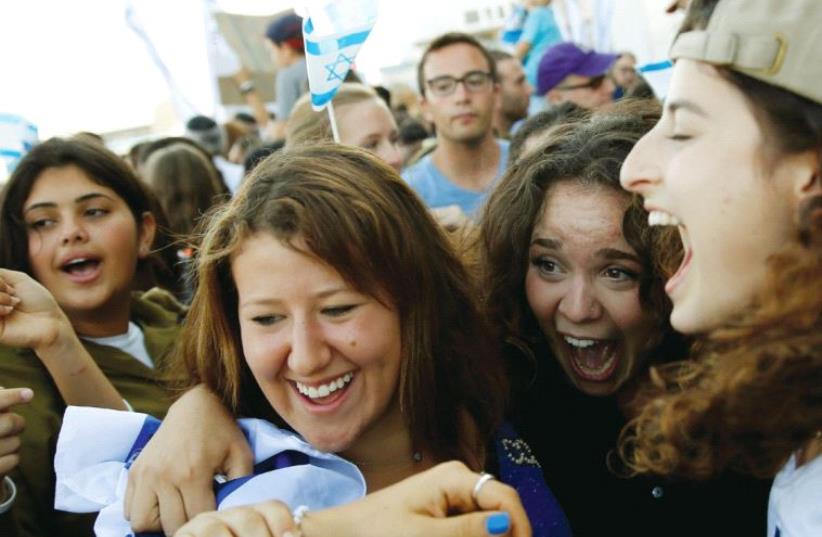 Newly arrived immigrants from North America react as they are welcomed after landing in Israel on a special flight organized by Nefesh B’Nefesh at Ben-Gurion International Airport (photo credit: REUTERS)