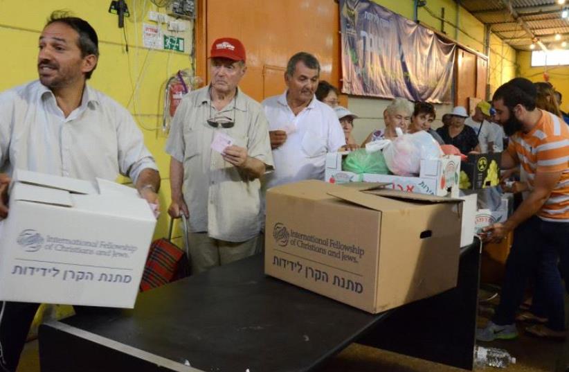 People receive IFCJ food packages prior to Rosh Hashana at the Yad B'Yad warehouse in Lod. (photo credit: IFCJ)