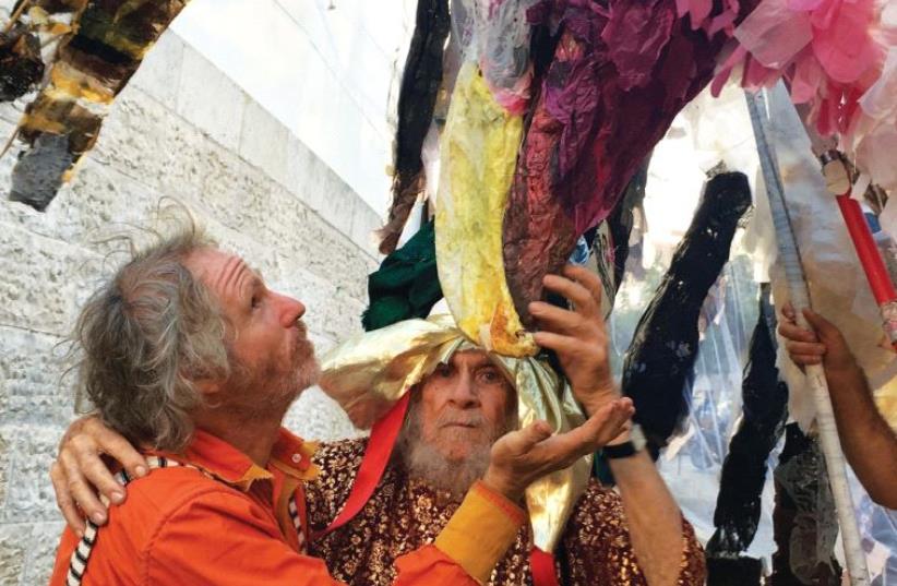 Puppeteer Adam Yachin gets up close to one of his large creations, together with his 92-year-old puppeteer father (photo credit: ROMI BAABUA)