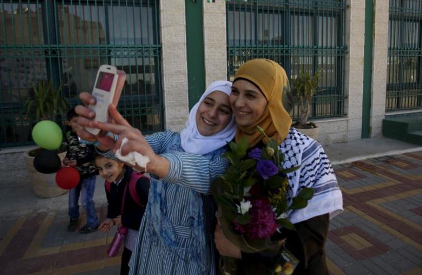 A Palestinian student takes a selfie with teacher Hanan Al Hroub, who is shortlisted to win the Global Teacher Prize, in the West Bank city of Ramallah February 17, 2016.  (photo credit: REUTERS)