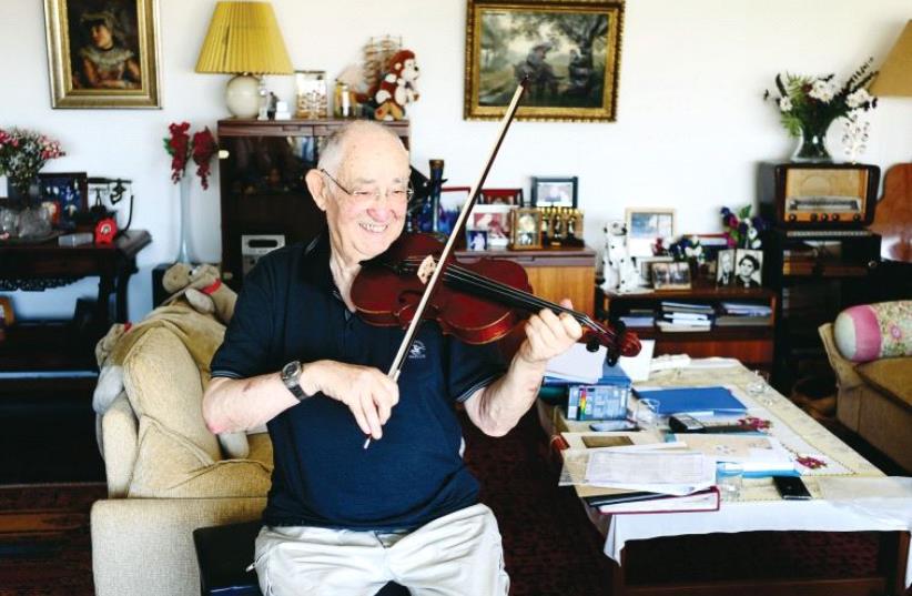 Yonatan Rosen playing his father’s violin (photo credit: YAD VASHEM)