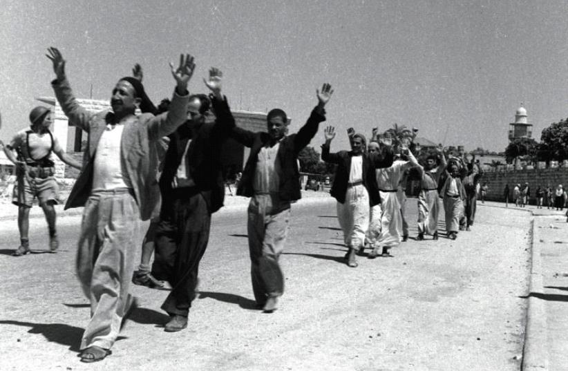 ARAB RESIDENTS of the town of Ramle raise their hands in surrender to Israeli soldiers on July 11, 1948 (photo credit: REUTERS)