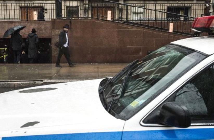 A police vehicle is seen outside a Brooklyn synagogue at the world headquarters of the Chabad-Lubavitch movement in New York City [File] (photo credit: REUTERS)