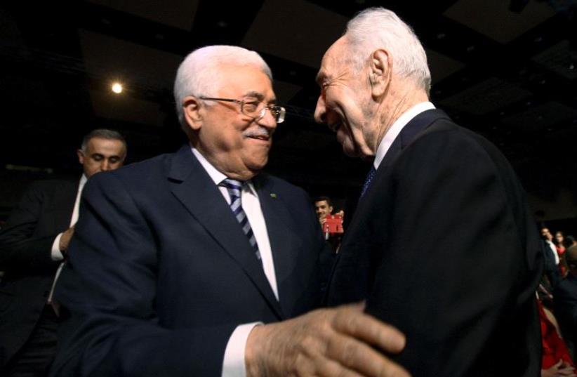  Former Israeli president Shimon Peres (R) shakes hands with Palestinian Authority President Mahmoud Abbas (C) at the World Economic Forum on the Middle East and North Africa at the King Hussein Convention Centre at the Dead Sea May 22, 2015 (photo credit: REUTERS)