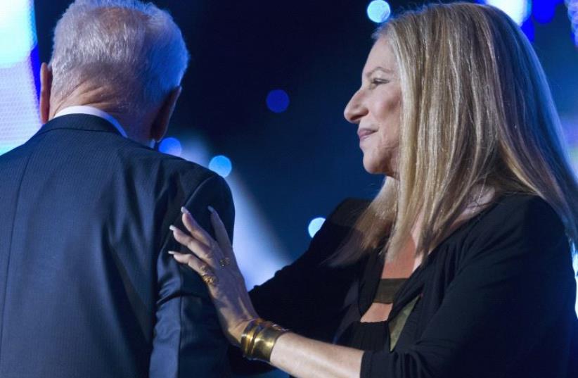 Shimon Peres with US singer Barbara Streisand after she sang at two songs durings Peres' 90th birthday celebration in 2013. (photo credit: REUTERS)
