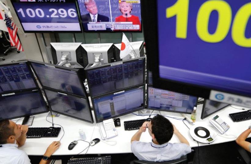 EMPLOYEES OF a foreign exchange trading company watch the first US presidential debate. (photo credit: REUTERS)