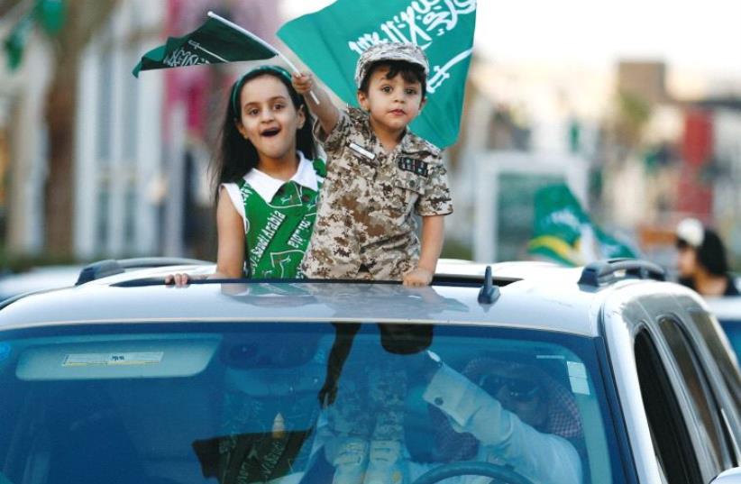 Saudi children ride in a car to celebrate Saudi National Day on a street in Riyadh, last week (photo credit: REUTERS)