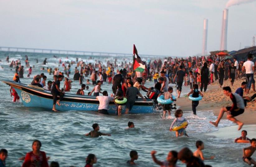 Palestinians swim in the Mediterranean Sea as they enjoy the warm weather in the northern Gaza Strip, August 14, 2015 (photo credit: REUTERS)