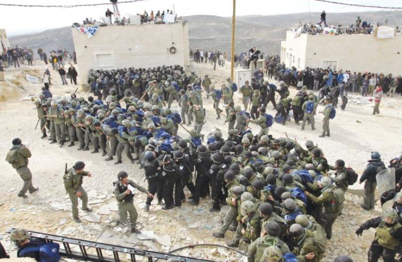 ISRAELI POLICEMEN gather in 2006 to remove the outpost of Amona. (photo credit: REUTERS)