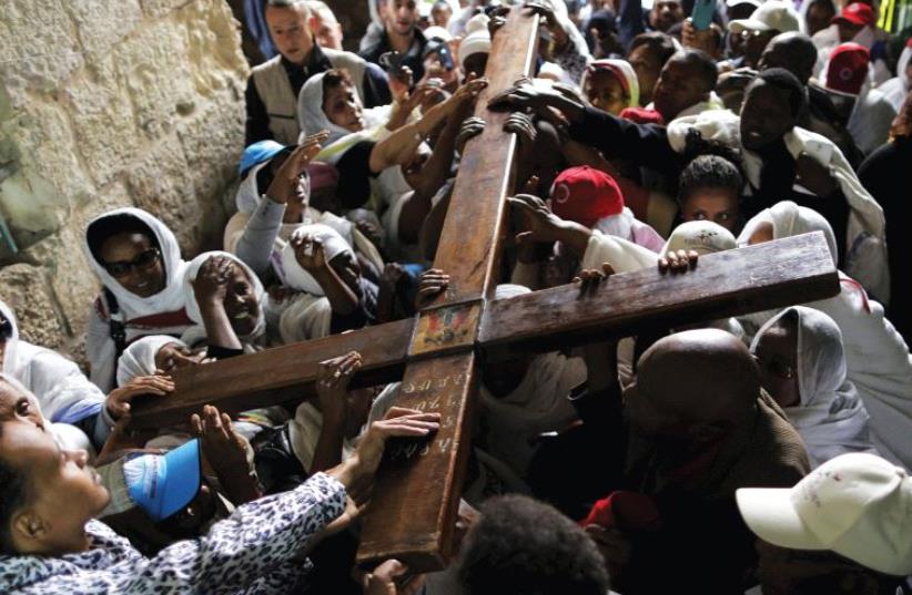 ETHIOPIAN CHRISTIAN worshipers carry a cross during a procession along Via Dolorosa (photo credit: REUTERS)