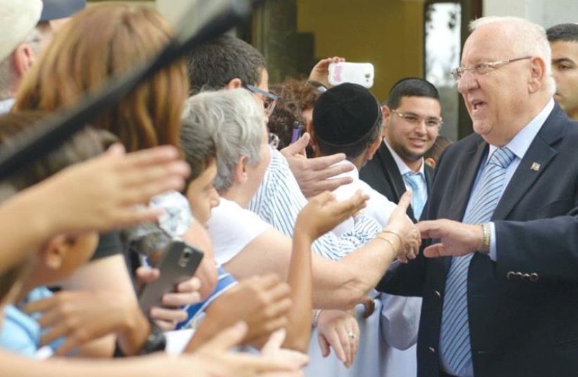 PRESIDENT REUVEN RIVLIN shakes hands with visitors at the President’s Residence. (photo credit: ROY BERKOVICH)