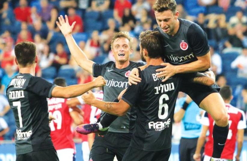 Hapoel Tel Aviv players celebrate with Edi Gotlieb (6) after he scored his team’s second goal in last night’s 2-0 win at Hapoel Haifa. (photo credit: ERAN LUF)