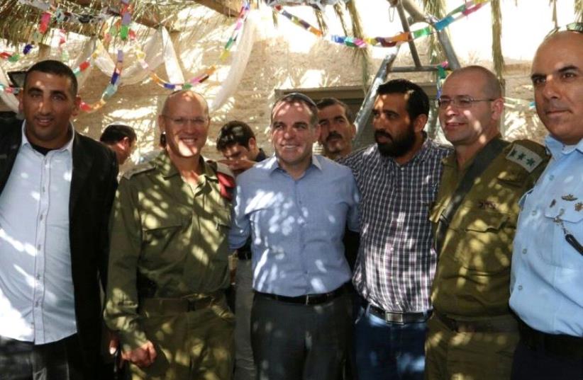 EFRAT COUNCIL head Oded Revivi hosts 30 Palestinians from the Bethlehem and Hebron area and representatives of the IDF and Border Police in his succa on Wednesday. (photo credit: SHMUEL FITOUSSI)