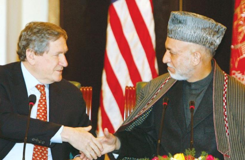 Afghanistan's President Hamid Karzai (right) shakes hands with US Special Representative to Pakistan and Afghanistan Richard Holbrooke (who died in December the following year) in Kabul February 15, 2009 (photo credit: REUTERS)