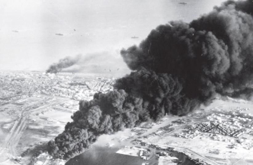 Smoke rises from oil tanks beside the Suez Canal hit during the initial Anglo-French assault on Port Said in November 1956 (photo credit: Wikimedia Commons)