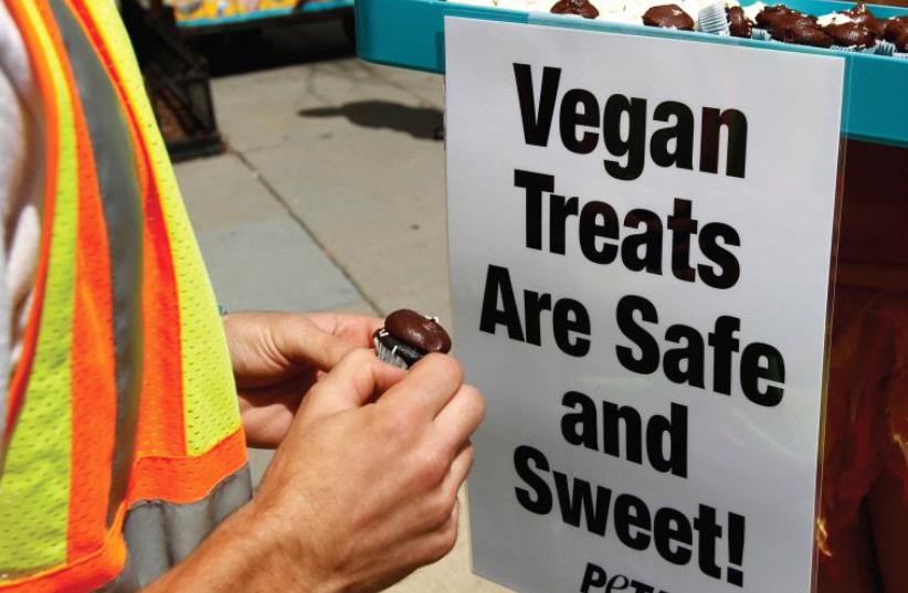 FOR YOUR dog also. A vegan activist hands out cupcakes in Washington. (photo credit: REUTERS)