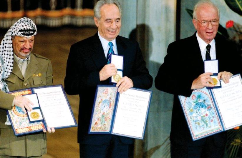 From left to right: PLO chairman Yasser Arafat, foreign minister Shimon Peres and prime minister Yitzhak Rabin show their shared Nobel Peace Prize awards to the audience in the Oslo City Hall in Oslo in this December 10, 1994, file photo (photo credit: GPO)