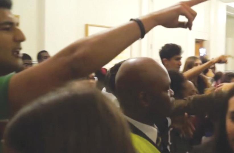 Protesters gesture as part of their efforts to stop an Israeli from speaking to students on the University College of London campus (photo credit: YOUTUBE)