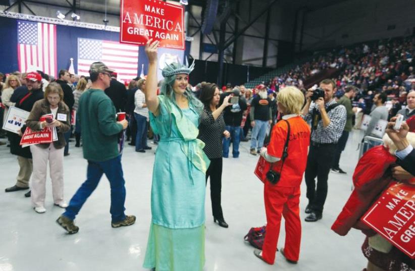 A supporter of US Republican presidential nominee Donald Trump dressed as the Statue of Liberty appears at campaign rally in Grand Rapids, Michigan, on October 31 (photo credit: REUTERS)