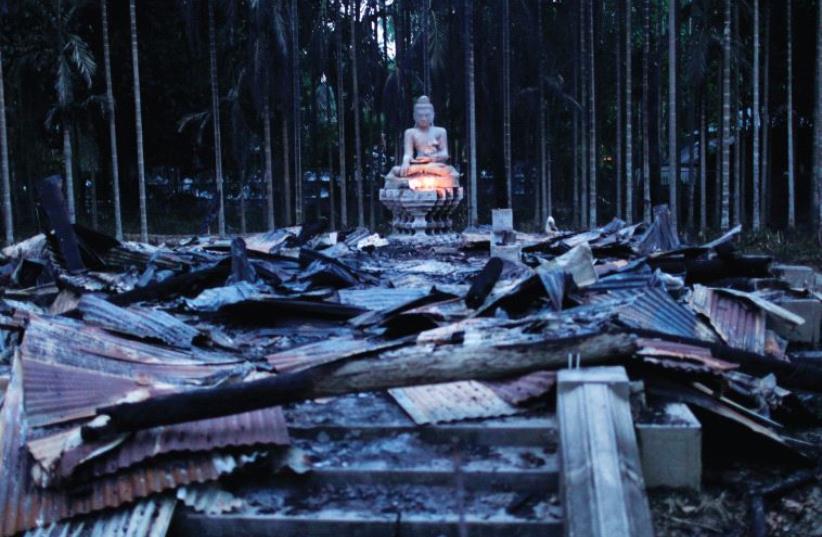 A BUDDHA sculpture sits atop wreckage after an attack against a Buddhist temple in Cox’s Bazar, Bangladesh. (photo credit: REUTERS)