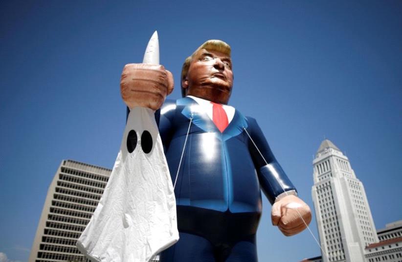 People march with an inflatable effigy of Republican presidential candidate Donald Trump during an immigrant rights May Day rally in Los Angeles, California, U.S., May 1, 2016 (photo credit: REUTERS)