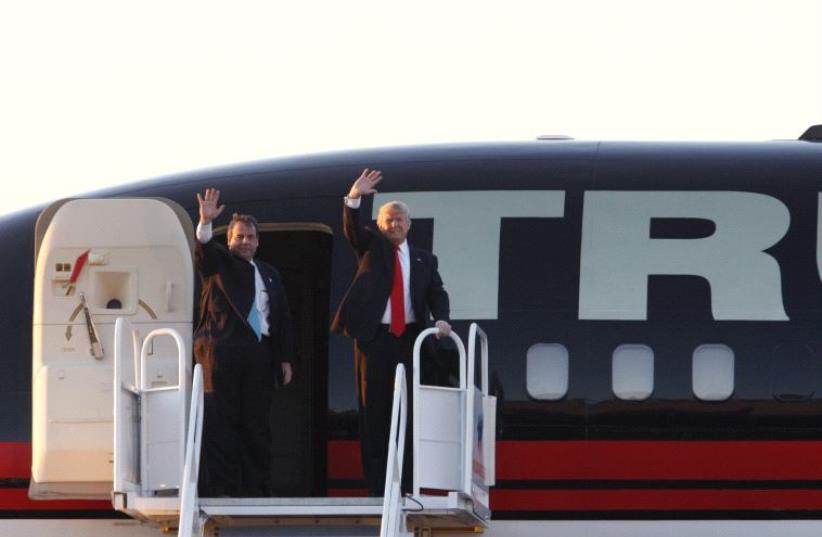 Governor Chris Christie (L) and current candidate Donald Trump (R) wave from Trump's jet.  (photo credit: REUTERS)