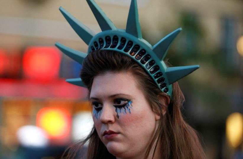 A demonstrator wears a headpiece depicting the crown of the Statue of Liberty during a protest in San Francisco, California, U.S. following the election of Donald Trump as the president of the United States November 9, 2016 (photo credit: REUTERS)