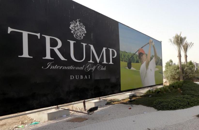 US real-estate magnate Donald Trump is seen playing golf on a billboard at the Trump International Golf Club Dubai in the United Arab Emirates on August 12, 2015 (photo credit: KARIM SAHIB/AFP)