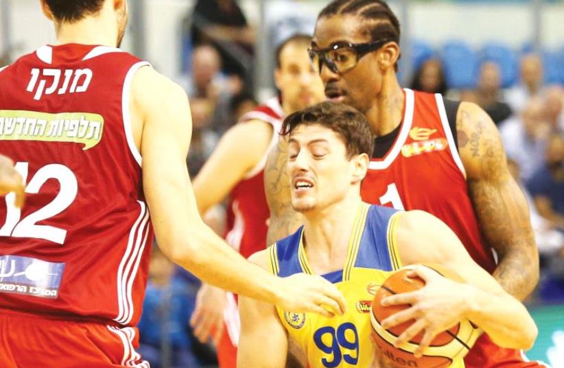 Maccabi Ashdod guard Yiftach Ziv (99) had 15 points, six rebounds and five assists in last night’s 70-57 BSL home victory over Amar’e Stoudemire (right) and Hapoel Jerusalem. (photo credit: DANNY MARON)