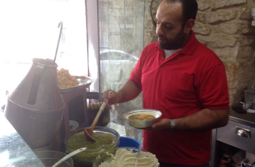 An Employee of Bandali prepares hummus  (photo credit: ELIYAHU KAMISHER)