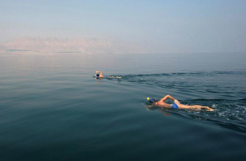 ENVIRONMENTAL ACTIVISTS take part in the Dead Sea Swim Challenge, swimming on Tuesday from the Jordanian to the Israeli shore. (photo credit: REUTERS)